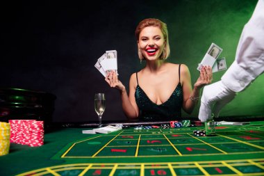 Mutlu ve çekici bir kızın fotoğrafı blöf yapmaktan zevk alır. VIP kumarhanesinde kumar oynarız. Dolar tutarız. Black Jack Jackpot kazanır..