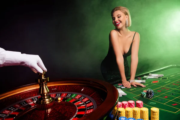 Photo of happy stunning gorgeous girl in vip casino club enjoy her victory playing with fortune wheel.