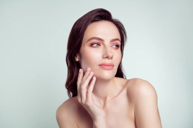 Çekici bir genç kadının fotoğrafı. Yanaklarındaki boş uzay spa salonu. Açık gri arka planda izole edilmiş..