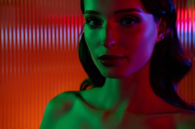 Modern fütüristik gece klübünde parıldayan cam kapılı zarif ve çekici bir kadının fotoğrafı tutkulu bir flörtü hisset..