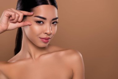 Muhteşem kadın parmaklarının fotoğrafı, bej rengi arka planda izole edilmiş kolajen maske kremini kaldıran yüze dokunuyor..