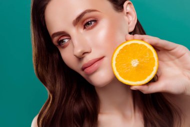 Sevimli, rüya gibi bir kadının çıplak omuzlarının elmacık kemiği turuncusu yarı izole yeşil arka plan..