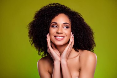 Mutlu estetik kız dokunuşunun fotoğrafı yeşil arka planda cilt için gençleştirici merhem uyguluyor..