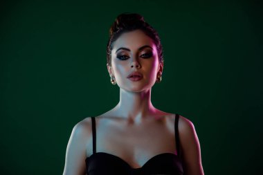 Göz kamaştırıcı model kız arkadaşın portresi. Pahalı küpeler ve yeşil arka planda izole edilmiş elmaslar..