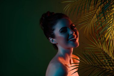 Mutlu bir bayanın tropikal orman lagün adasında güneşlenirken çekilmiş fotoğrafı neon yeşil arka planda cenneti tanıtır..