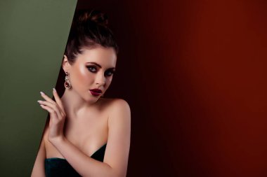 Milyoner bir bayanın haki rengi beyaz tahta saklarken çekilmiş fotoğrafı kırmızı arka planda izole edilmiş lüks elmas aksesuarların keyfini çıkarın..