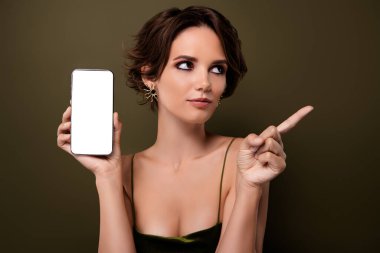 Şık, çekici bir kızın fotoğrafı. Akıllı telefon aygıtı, işaret parmağıyla yeşil renkli boş alan arkaplanı gösteriyor..