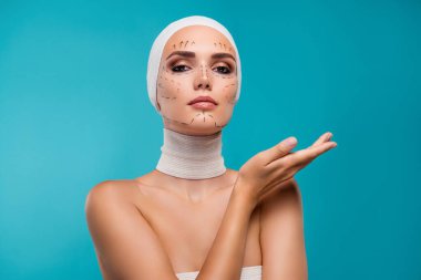 Kadın estetik tıp uzmanının fotoğrafı. Cyan boş alan arkaplanı üzerinde tanıtım yapıyor..