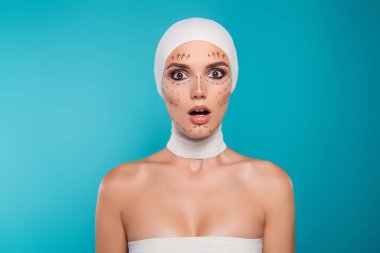 Tıbbi bandajlı kadının fotoğrafı. Plastik cerrahi hastası. Cyan rengi yüzünden şaşırmış görünüyor..
