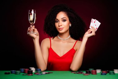 Zarif ve güzel bir bayanın gece kumarhanesinde geçirdiği fotoğraf koyu kırmızı arka planda izole edilmiş..