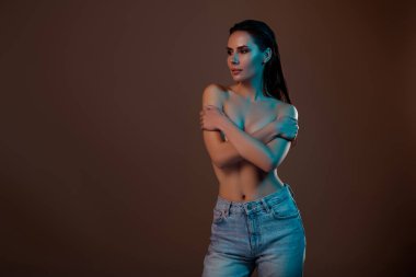 Muhteşem zarif bir bayanın fotoğrafı. Kahverengi arka planda izole edilmiş banyo sonrası kendine sarılıyor..