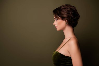 Klas kız arkadaşın profil tarafı fotoğrafı yeşil boş alan arkaplanına bak, moda gece elbisesi giyiyor..