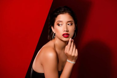 Çekici Koreli genç bayanın fotoğrafı... boş alanı baştan çıkar... kırmızı arka planda izole edilmiş siyah deri elbise giy..