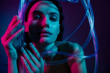 Kadın dokunuşunun fotoğrafı plastik kablolar izole edilmiş parlak ultraviyole neon arkaplan rengi gibi görünüyor..