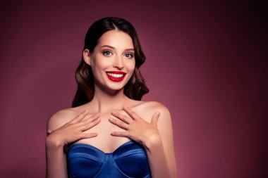 Neşeli kızın fotoğrafı mavi moda elbisesi giyer, el ele tutuşur göğsü kahverengi arkaplan üzerine izole olur..