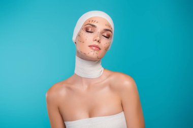 Tıbbi bandaj çizgileri olan estetik cerrahi hastası bir kadının fotoğrafı. Cyan renk arkaplanı üzerinde gözleri kapalı..