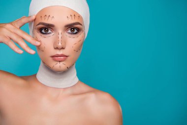 Plastik cerrahi hastası kadının arka plan renginde fotoğrafı. Parmaklar yanaklara değsin..