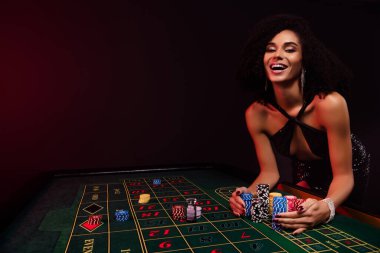 Poker oynayan mutlu bir kadının pokerde çekilen fotoğrafı. Milyon dolarlık para, partide büyük ikramiyeyi kazanmış gibi..