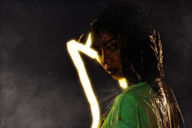 Çekici kadın sezon indirimli poster kolajı. Kauçuk palto gecesi. Işıklı arka plan morötesi..