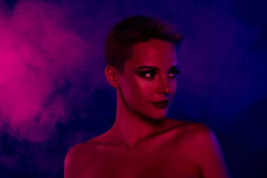 Siyah makyajlı kısa saçlı bir kadının fotoğrafı neon ışıklı, boş bir arkaplana bakın..