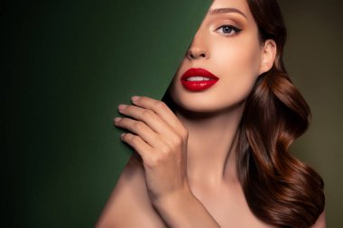 Vogue dergisi için poz veren göz kamaştırıcı, klas, kapalı yüzlü, yeşil posterli, boş bir portre..