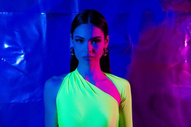 Kendine güvenen güzel model kadının portresi. Boş mekan pozu veren, canlı, neon renkli stüdyo afişi..