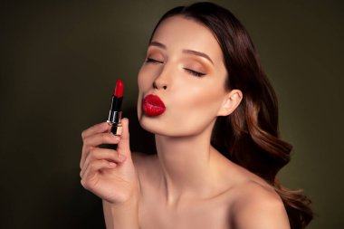 Göz kamaştırıcı cazibeli kadının portresi. Dudaklarını üflüyor. Gece kulübüne hazırlanan kırmızı renk lekelerini gösteriyor..