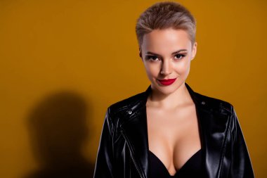 Deri ceketli çekici bir kadın. Baştan çıkarıcı giyinmiş, koyu renkli arka planda izole edilmiş siyah sutyen..