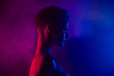 Profil tarafı fotoğrafı. Mavi, parlak, boş bir arkaplanda, neon sisli efektli..