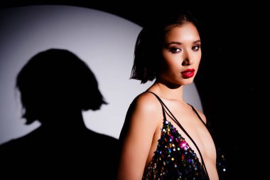 Güzel bir kızın profil fotoğrafı. Parlak parlak elbiseler giyip VIP sahne ışıkları altında poz veriyor..