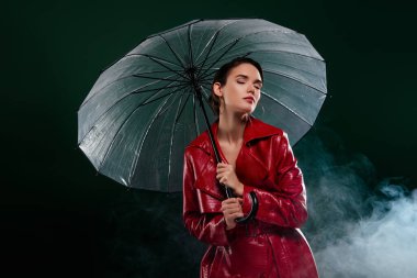 Bayanın fotoğrafı neşe şemsiyesini kapalı, koyu renk arka planda tut.