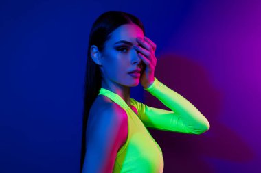 Oldukça kadınsı model bir kızın profil fotoğrafı. Kol kapağı, göz teması, parlak neon arka planda izole edilmiş..