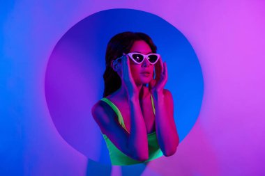 Kızın güneş gözlüğü taktığı fotoğraf. Pembe boş uzay afişi. İzole edilmiş neon rengi arka plan..