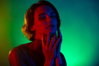 Kadın dokunuşunun yanaklarının fotoğrafı çene izole edilmiş neon renkli arka plan..