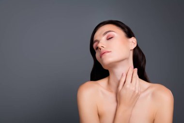 Boş uzayda bir kadının fotoğrafı. Elleri, elleri, gözleri kapalı. Gri arkaplan izole edilmiş..