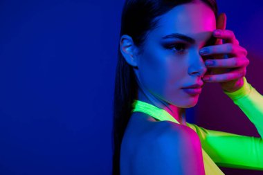 Güzel model kızın kesilmiş profil portresini kapat. El dokun, göz kapağını kapat. Neon arka planda izole edilmiş boş alan..