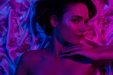 Uykulu, şirin bir dokunuşun fotoğrafı. Çene pürüzsüz, temiz cilt mükemmelliği. Kaplıcada neon yapraklı romantik ketenler giydikten sonra..