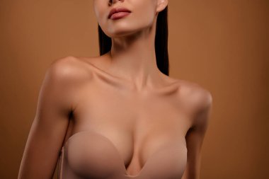 Çekici bir kızın kesilmiş fotoğrafı yepyeni bir sütyen giyer ve pastel arka plan izole edilmiş iç çamaşırı giyer..