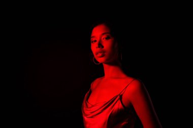 Baştan çıkarıcı güzel bir bayanın fotoğrafı şık bir elbise giy. Büyüleyici olaylardan zevk al. Boş alan izole edilmiş siyah arkaplan..