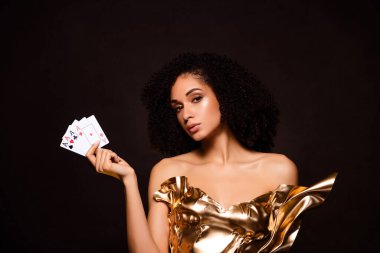 Çekici bayanın kazandığı fotoğraf. Poker kartları oynarken koyu renkli arka plan..