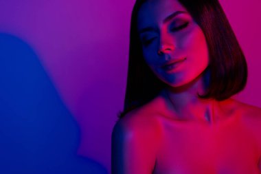 Kapalı gözlü bir kızın fotoğrafı şefkat duygusunu izole edilmiş neon rengi arka planda hisseder..