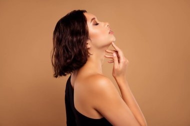 Çekici, baştan çıkarıcı bir bayanın fotoğrafı omuz zırhını aşındırıyor. Tecrit edilmiş bej rengi arka plan işlemleri zevkle kaldırıyor..