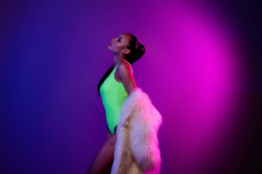 Canlı renkli neon arka planda izole edilmiş kürk giyen barışçıl model kızın profil fotoğrafı..