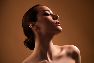 Bej rengi arka planda izole edilmiş güzellik prosedüründen sonra ideal pürüzsüz tenin tadını çıkaran nefes kesici rüya gibi kızın fotoğrafı.