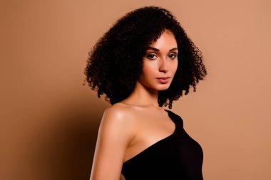 Sırrı açık, çarpıcı, takım elbiseli, boş alan izole edilmiş bej arka plan pozu veren bir kadın fotoğrafı..