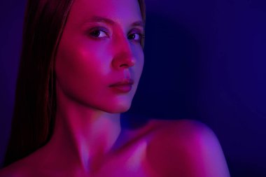 Göz kamaştırıcı, çekici bir kadının fotoğrafı. Kendini izole edilmiş, parlak neon bir arka plan gibi hisset..