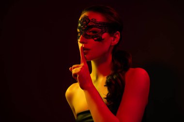 Çekici kadın çıplak omuzlu dantel maskenin fotoğrafı. Gizli, izole, turuncu, açık renkli arka plan..