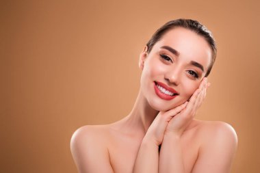 Göz kamaştırıcı rüya gibi bir bayanın fotoğrafı. İki kollu yanak. Bej rengi arka planda izole edilmiş güzellik uzmanının derisinden zevk alıyor..