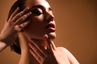 Çıplak omuzlu şehvetli güzellik modeli kozmetoloji prosedürünün reklamını yapıyor. Bej arka planda yüz derisi..