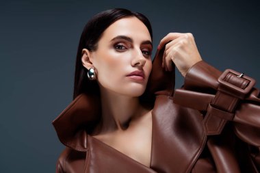 Çekici bir kadının portre çekimi. Gri arka planda izole edilmiş güzel afiş dergisi kapağı..